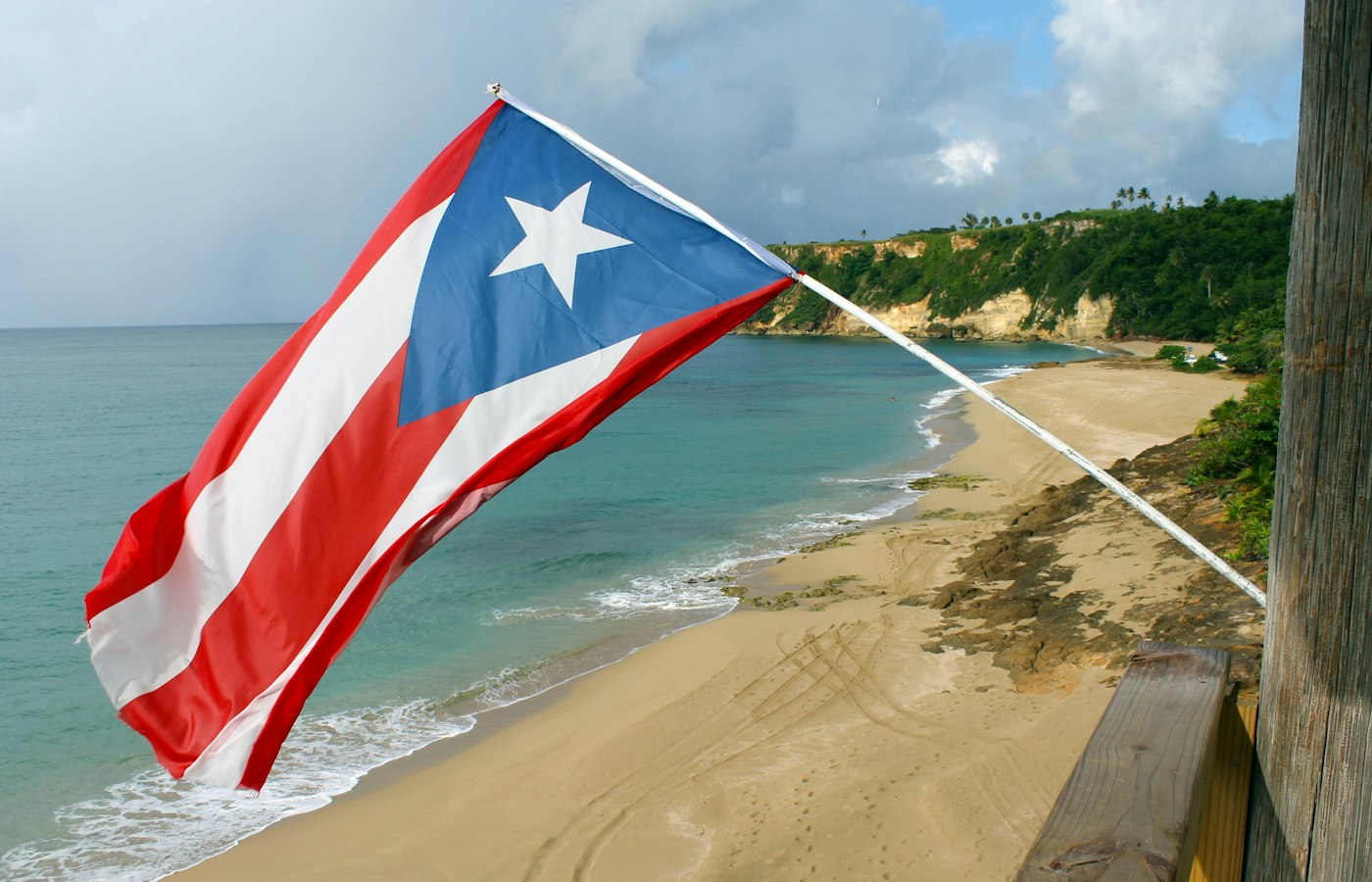 Bandera de Puerto Rico frente a una playa – mudarse a Puerto Rico bajo la Ley 60